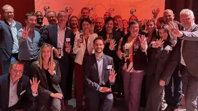 Een dertigtal collega's van P&V Groep poseren met de vier Decavi-trofeeën